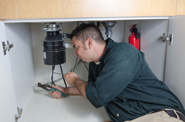 how to install a garbage disposal - plumber fixing disposal
