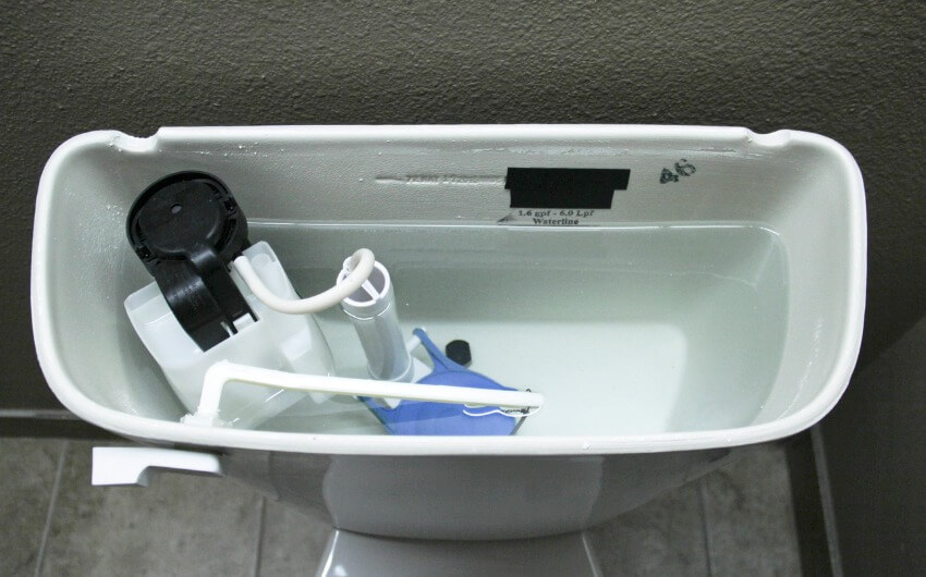Overhead view of slow flushing toilet tank and overflow tube
