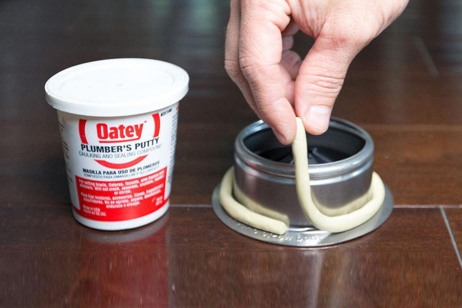 How to use plumbers putty male hand applying Oatey plumbers putty to metal part