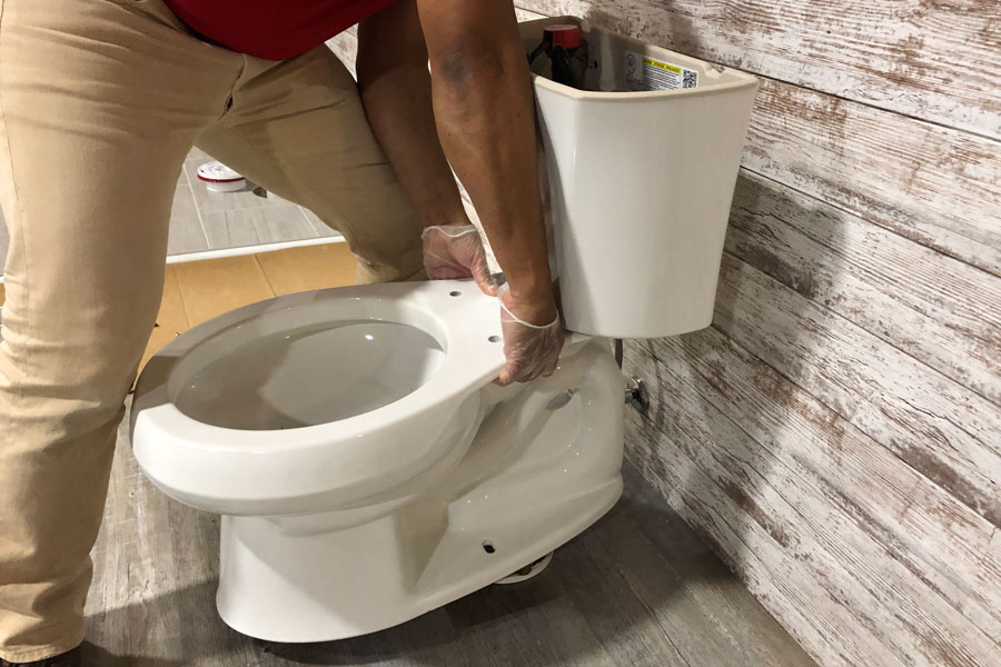 man reseating toilet - wobbly toilet