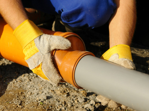 plumber insuring proper slope of drain pipe - san antonio plumbing codes