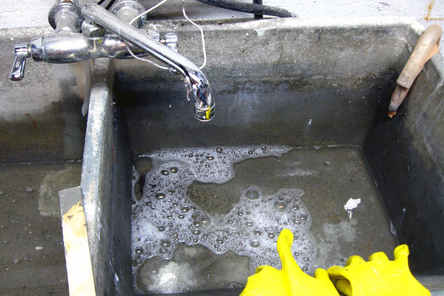 This laundry room sink is slowly draining which means it's clogged. It definitely needs a drain cleaning.