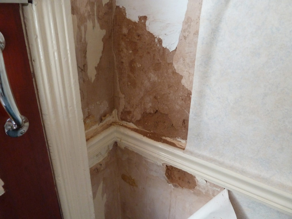 Water damage on walls from flooded bathroom
