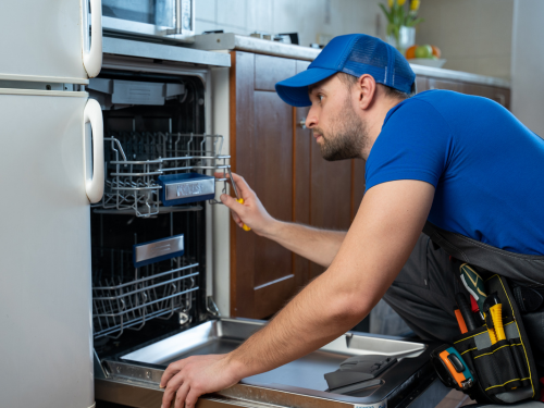 repairman fixing dishwasher